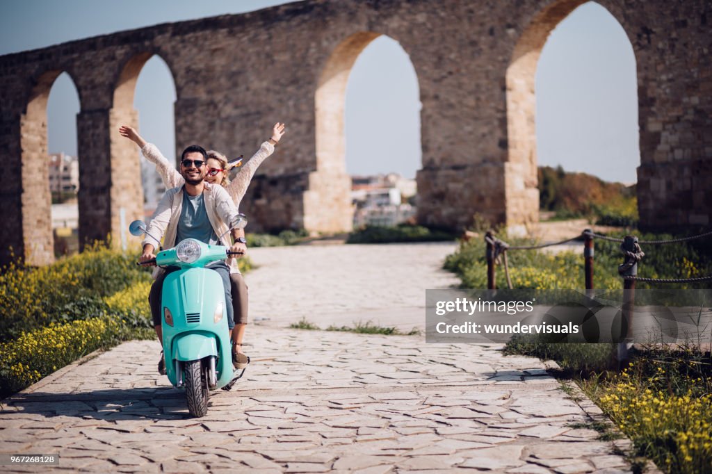 Junge Touristen paar Reiten Vintage Roller in der Europäischen Stadt