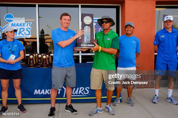 Head coach Derrick Racine of the University of West Florida is presented with the National Runner-up trophy during the Division II Women's Tennis...