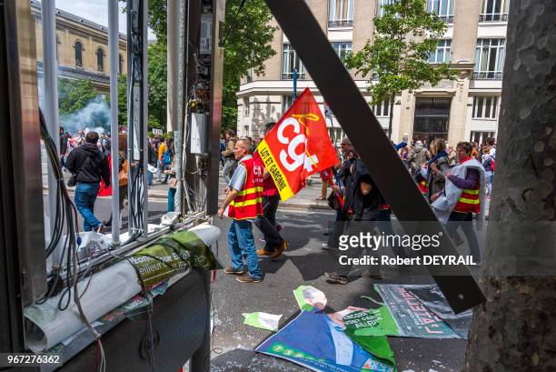 Manifestants CGT passant devant un abribus endommagé lors de la manifestation contre la loi travail dite 'Loi Khomry' le 14 juin 2016, Paris, France....