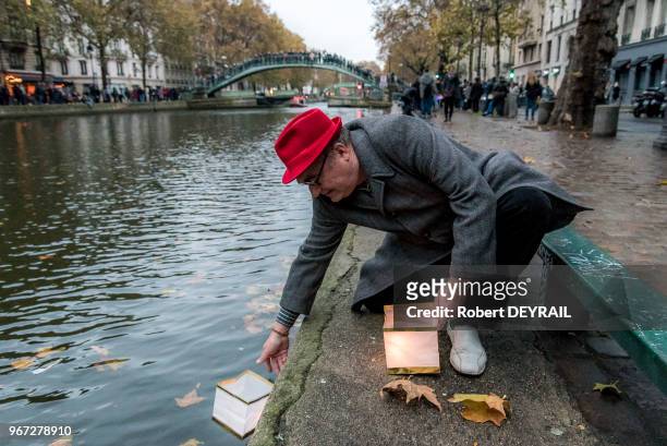Un anonyme dépose un lampion dans le canal Saint Martin en signe de solidarité, le 13 novembre 2016, Paris, France.