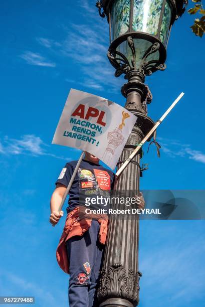 Enfant tenant une pancarte "APL, Macron rend l'argent" lors de la manifestation du mouvement "La France Insoumise" depuis la place de la Bastille...