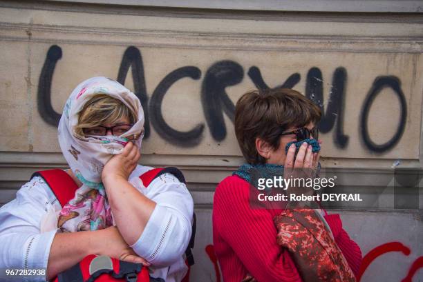 Manifestantes se protégeant du gaz à lacrymogène lors de la manifestation contre la loi travail dite 'Loi Khomry' le 14 juin 2016, Paris, France. 80...