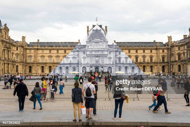 Artiste français JR a realisé sur une des faces de la pyramide du Louvre, une image anamorphosée de 550 m2 reproduisant la partie de la façade Sully...