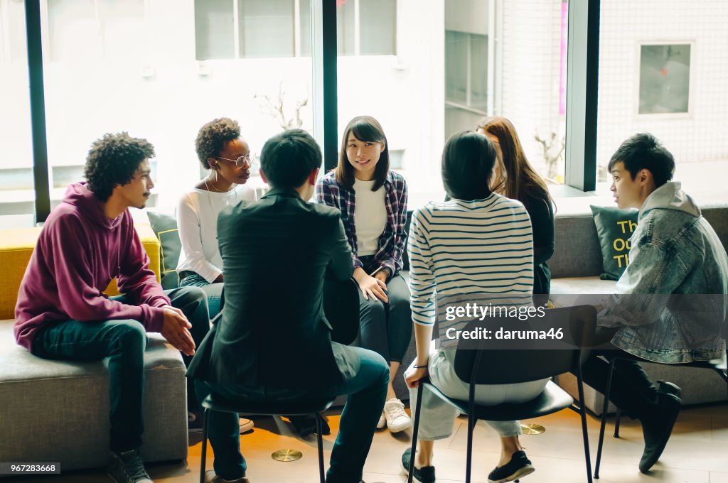 Young men and women discussing at the cafe.