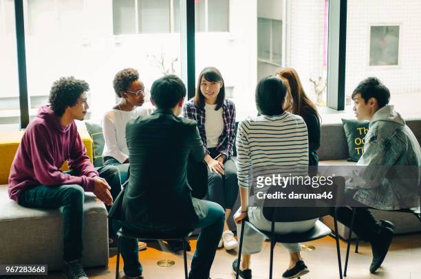 young men and women discussing at the cafe. - youth culture stock pictures, royalty-free photos & images