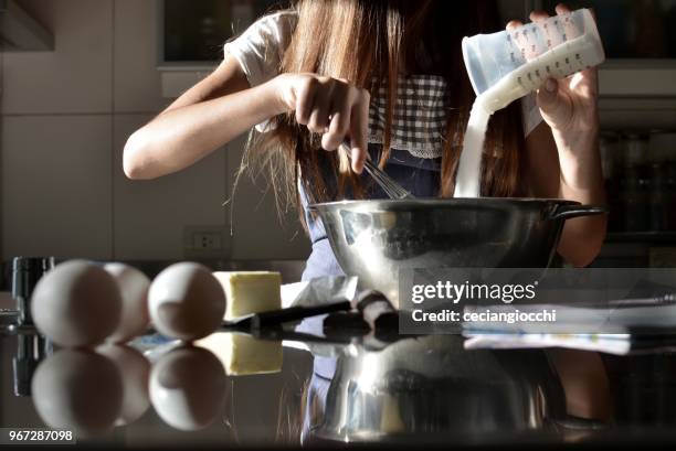 teenage girl standing in kitchen baking a cake - mixing stock pictures, royalty-free photos & images