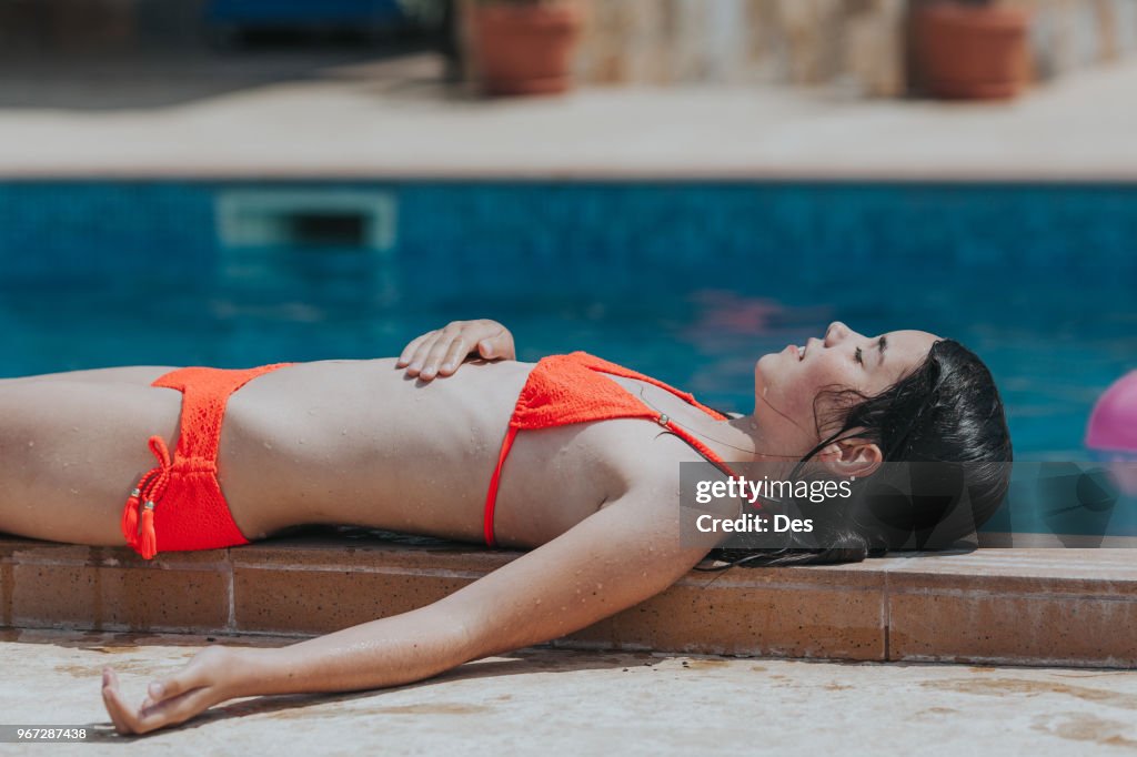Girl Lying By A Swimming Pool Sunbathing High-Res Stock Photo - Getty Images