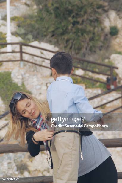 mother putting a belt in her son's trousers - putting clothes son stock pictures, royalty-free photos & images