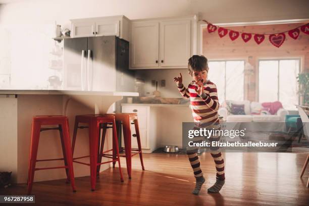 boy dancing in the kitchen in his pyjamas - young people dancing stock pictures, royalty-free photos & images