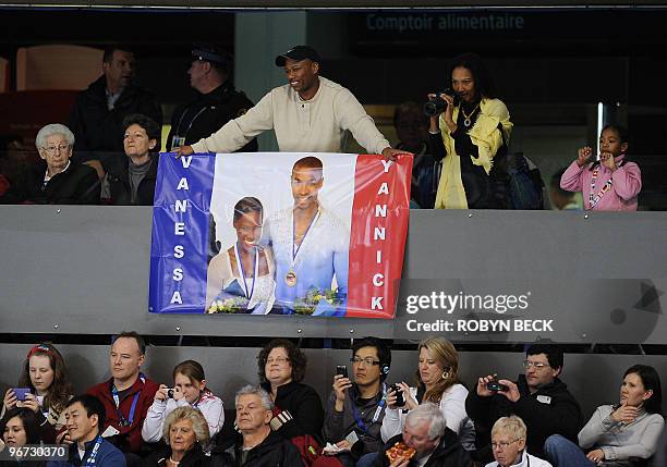 Fans of French skaters Vanessa James and Yannick Bonheur hold a sign during the figure skating pairs free program at the 2010 Winter Olympics at the...