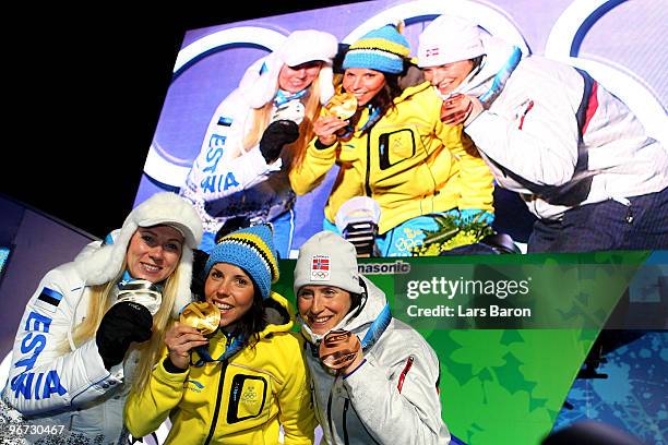 Kristina Smigun-Vaehi of Estonia poses with the silver medal, Charlotte Kalla of Sweden poses with the gold medal and Marit Bjoergen of Norway...