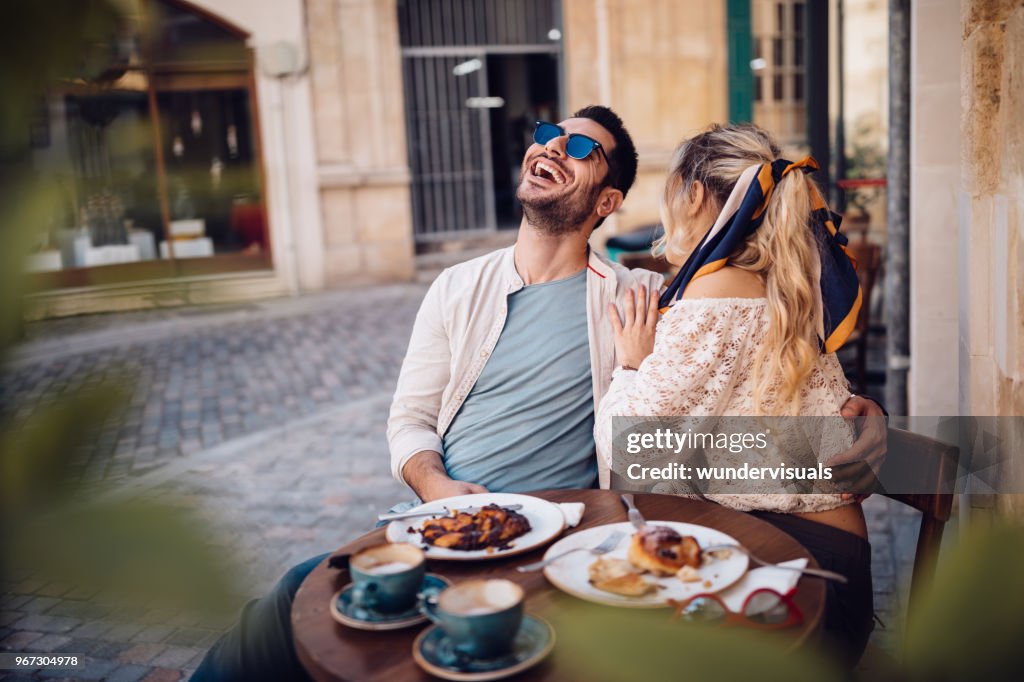 Young couple drinking coffee and having fun at coffee shop