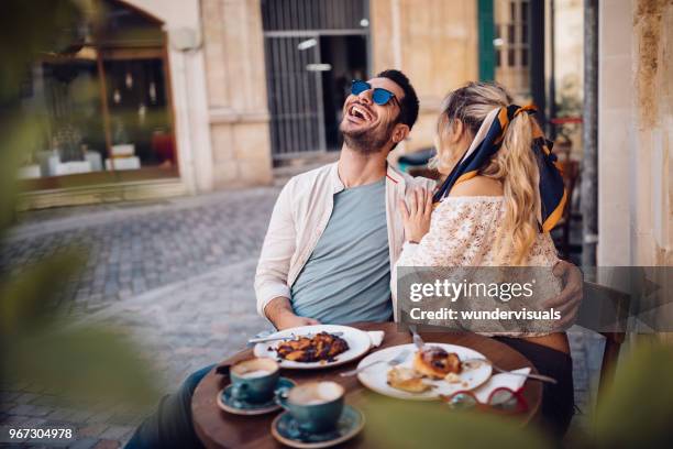 young couple drinking coffee and having fun at coffee shop - restaurant city stock pictures, royalty-free photos & images