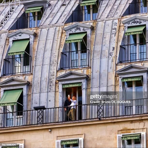 Une femme prenant en photo avec son smartphone la vue sur Paris depuis l'Hôtel Le Meurice sur la rue de Rivoli, 17 juin 2017, Paris, France.