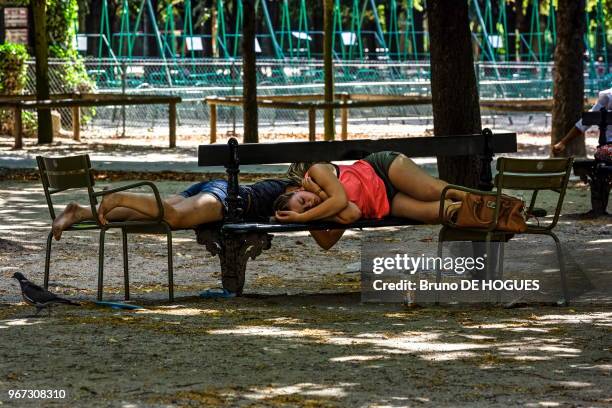 Deux jeunes femmes touristes allongees sur un banc en train de dormir dans le Jardin du Luxembourg le 19 Juillet 2013, Paris, France.