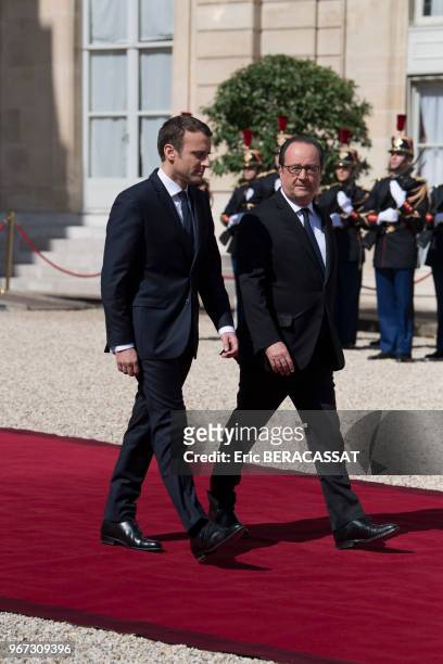 Le nouveau président de la République Emmanuel Macron raccompagne son prédécesseur François Hollande à la sortie du Palais de l'Elysée le 14 mai 2017...