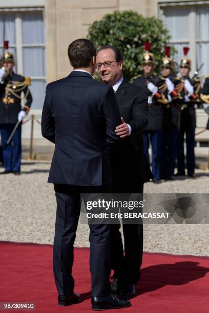 Le nouveau président de la République Emmanuel Macron raccompagne son prédécesseur François Hollande à la sortie du Palais de l'Elysée le 14 mai 2017...