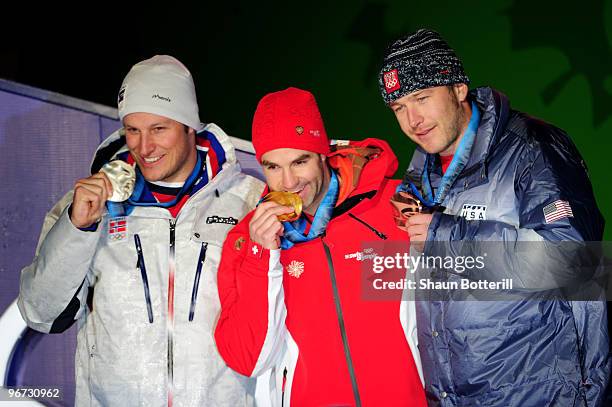 Aksel Lund Svindal of Norway celebrates winning the silver, Didier Defago of Switzerland poses with the gold and Bode Miller of the United States...