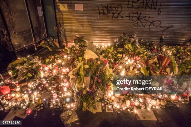 De nombreuses personnes viennent se recueillir et apporter fleurs et bougies devant le rideau baissé du bar 'La belle équipe', le 14 Novembre 2015 à...