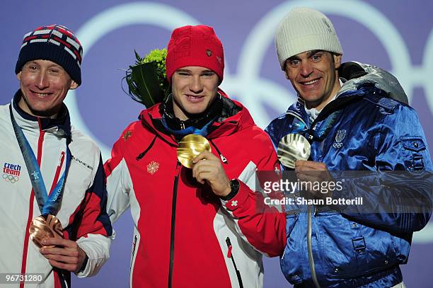 Lukas Bauer of Czech Republic celebrates with the bronze, Dario Cologna of Switzerland celebrates with the gold and Pietro Piller Cottrer of Italy...