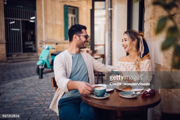 young couple having brunch at traditional cafe in europe - holiday romance stock pictures, royalty-free photos & images