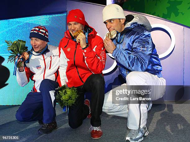 Lukas Bauer of Czech Republic celebrates with the bronze, Dario Cologna of Switzerland celebrates with the gold and Pietro Piller Cottrer of Italy...