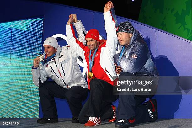 Aksel Lund Svindal of Norway celebrates winning the silver, Didier Defago of Switzerland poses with the gold and Bode Miller of the United States...