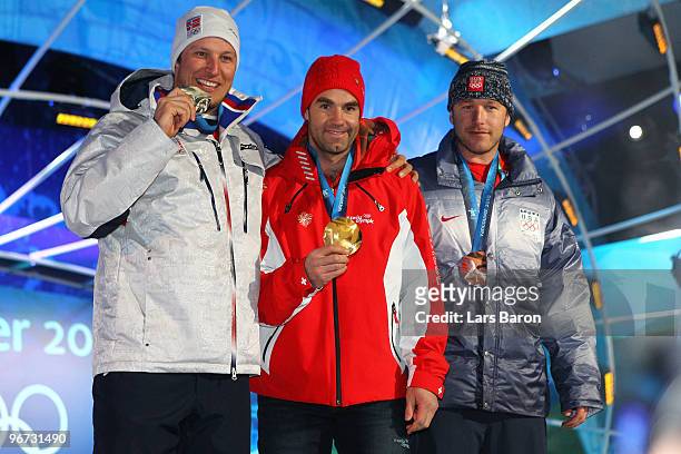 Aksel Lund Svindal of Norway celebrates winning the silver, Didier Defago of Switzerland poses with the gold and Bode Miller of the United States...