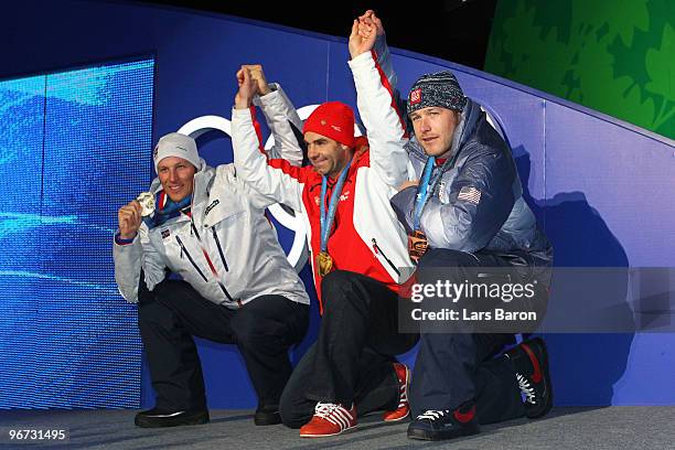 Aksel Lund Svindal of Norway celebrates winning the silver, Didier Defago of Switzerland poses with the gold and Bode Miller of the United States...