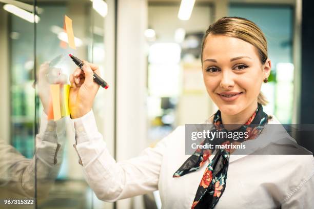 femme d’affaires à la recherche intelligente dans son bureau - matrixnis photos et images de collection