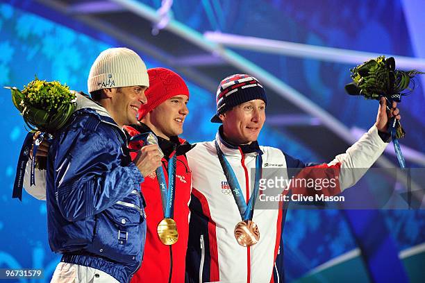Pietro Piller Cottrer of Italy celebrates winning silver, Dario Cologna of Switzerland gold and Lukas Bauer of Czech Republic bronze celebrates with...
