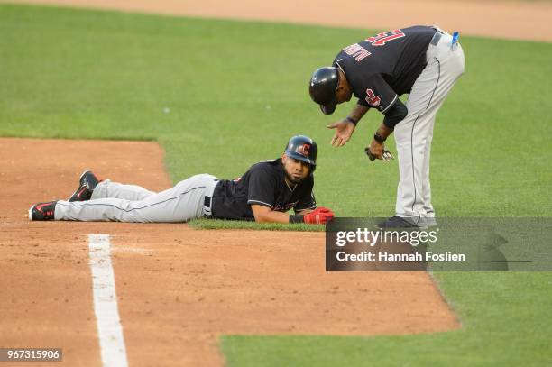 First base coach Sandy Alomar Jr. #15 of the Cleveland Indians speaks with Melky Cabrera after he was tagged out by the Minnesota Twins during the...