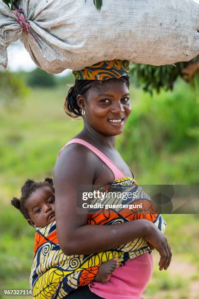 赤ちゃんを持つ女性は、負荷を運ぶ大きな彼女の頭の上 dr コンゴ - コンゴ共和国 ストックフォトと画像