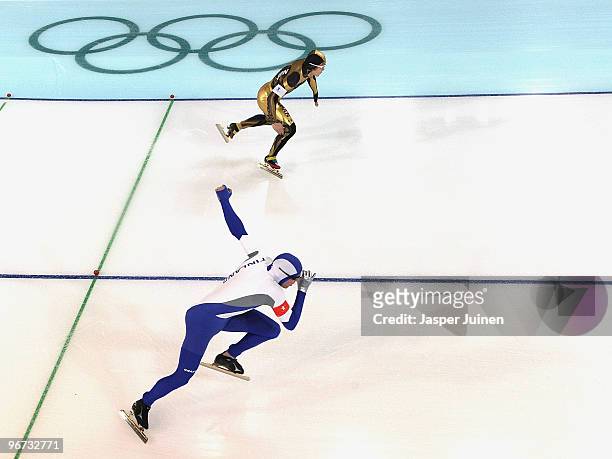 Mika Poutala of Finland and Joji Kato of Japan compete in the men's speed skating 500 m final on day 4 of the Vancouver 2010 Winter Olympics at...