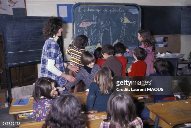 Jeunes élèves dessinant le naufrage du pétrolier Amoco Cadiz dans une école le 21 mars 1978 à Portsall, France.