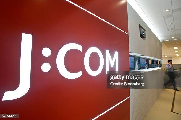 An employee of Jupiter Telecommunications Co. Looks at a television monitor displayed in the reception area of the company's headquarters in Tokyo,...