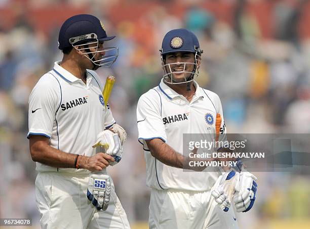 Indian cricketer Mahendra Singh Dhoni shares a light moment with teammate VVS Laxman as they walk off the ground at the lunch interval during the...