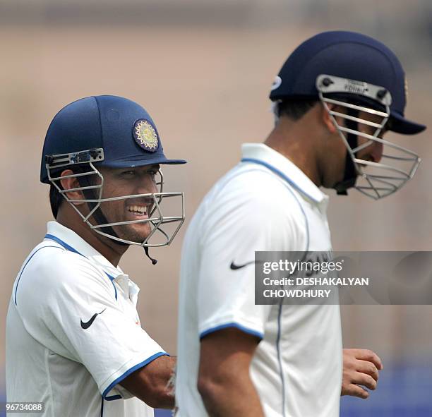 Indian cricketer Mahendra Singh Dhoni shares a light moment with teammate VVS Laxman as they walk off the ground at the lunch interval during the...