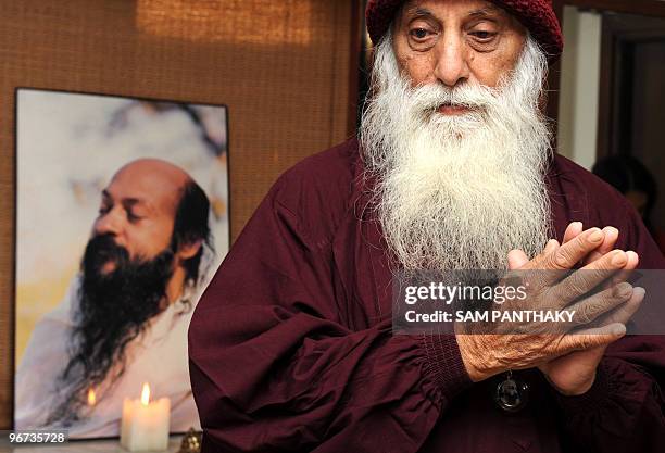 Osho follower Swami Anand Ghan gestures as a meditation service takes place in Ahmedabad on February 16 in memory of those killed in the Pune bomb...