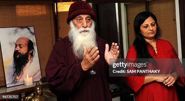 Osho follower Swami Anand Ghan gestures alongside Maa Divyam Bharti as a meditation service takes place in Ahmedabad on February 16 in memory of...