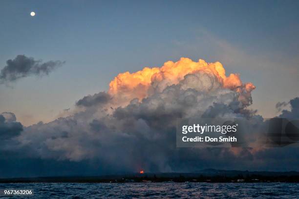 Lava from the Kilauea volcano creates a toxic cloud of sulfuric acid at dawn on May 31, 2018 in Pahoa, Hawaii. A full moon sets over the toxic cloud....