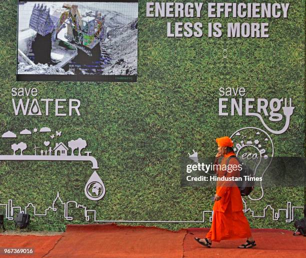 Man walks in front of a poster which explains waste management and recycling at an exhibition hall on the occasion of World Environment Day at...