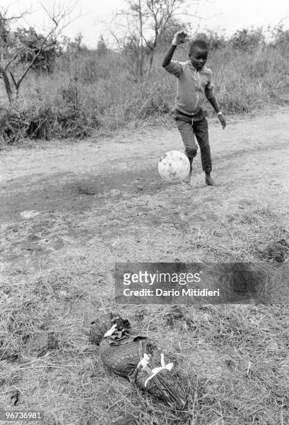The body of a child who survived the 1994 Rwandan genocide, but later died following a deadly outbreak of cholera, is left for collection on the side...