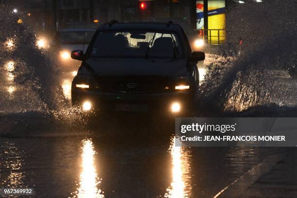 Car drives in a flooded street during a storm, on June 4, 2018 in Le Mans, northwestern France.