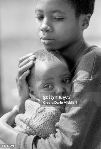 Girl and her younger brother who witnessed the killing of their parents during the 1994 Rwandan genocide waiting for help in a refugee camp in Goma,...