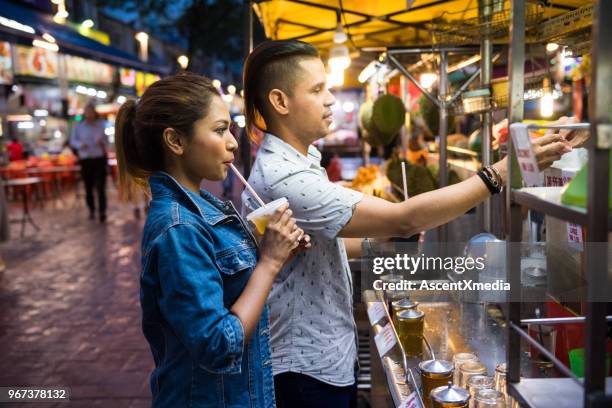 couple enjoying local cuisine at a night market - food stand stock pictures, royalty-free photos & images