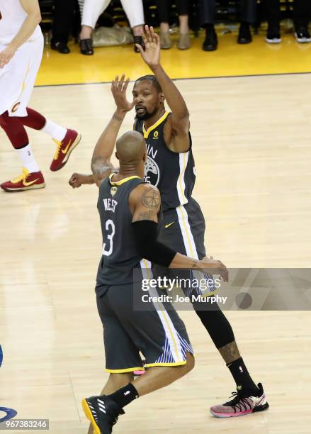 David West and Kevin Durant of the Golden State Warriors exchange high fives in Game Two of the 2018 NBA Finals against the Cleveland Cavaliers on...