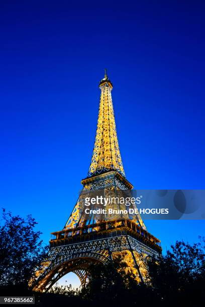 Tour Eiffel avec son éclairage scintillant à la tombée de la nuit à Paris, France.