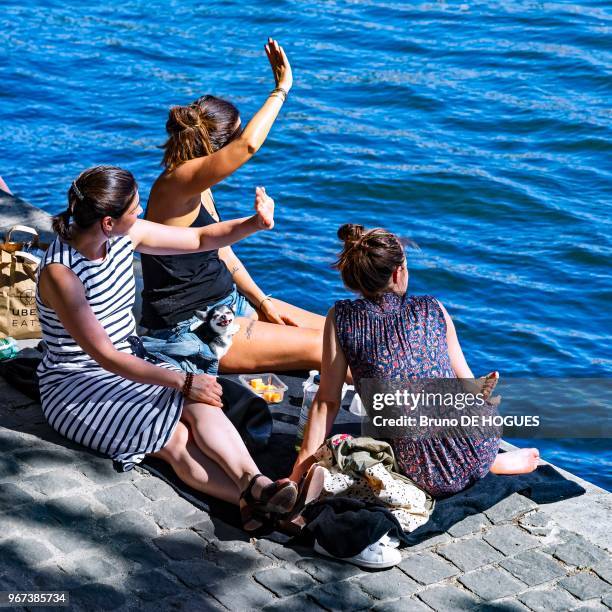 Trois jeunes femmes par une forte chaleur sur le Quai des Tuileries, 25 mai 2017, Paris, France.