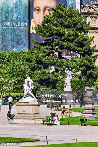 Des gens bronzant dans le Jardin des Tuileries sous le portrait de la Joconde, 26 mai 2017, Paris, France.